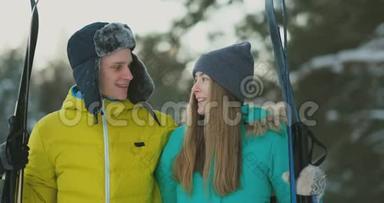 可爱的男人和女孩在冬天的森林里缓慢地滑雪，微笑着看着对方